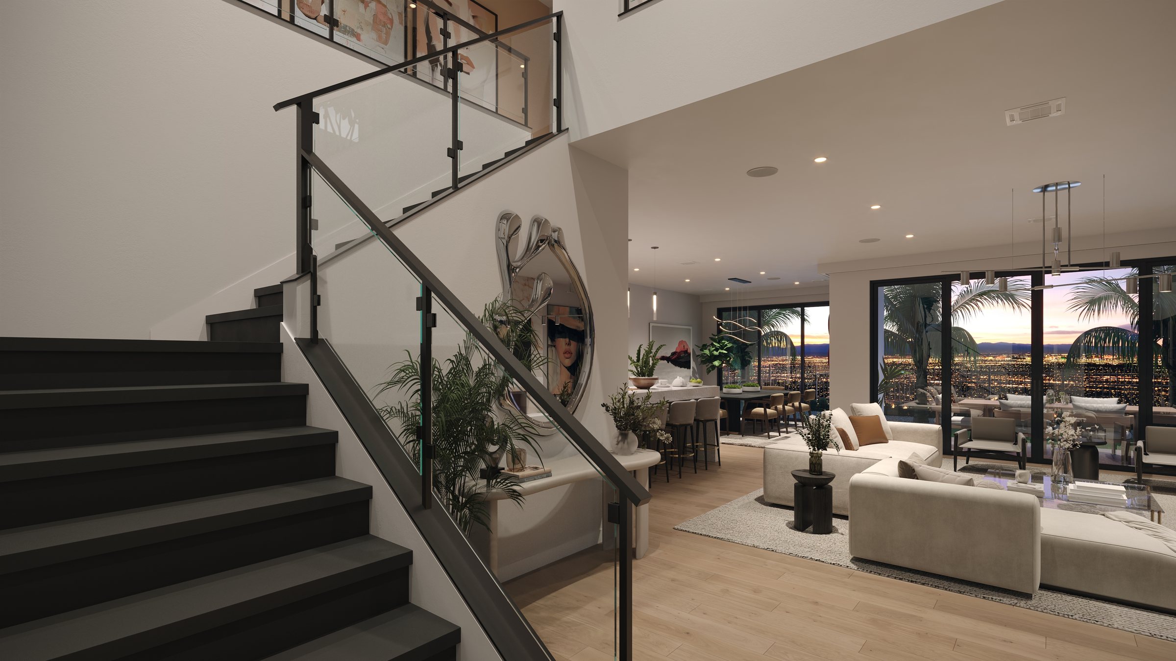 The foyer and stair at Rocky Ridge at dusk, with a glass and steel rail, an open great room beyond and the city lights of the valley through the sliding glass doors.